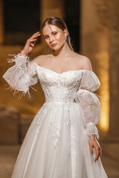 Modelo de vestido de novia sin tirantes con detalles de plumas