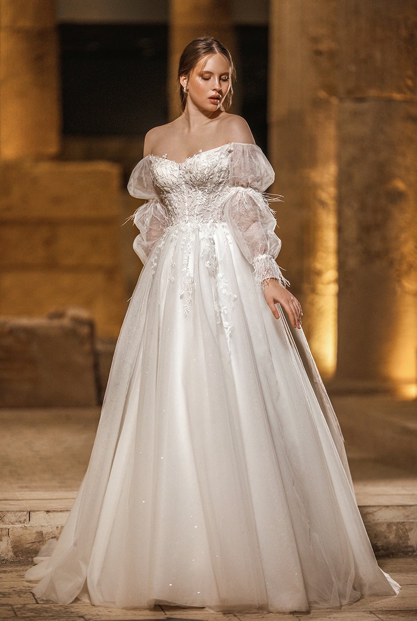 Modelo de vestido de novia sin tirantes con detalles de plumas