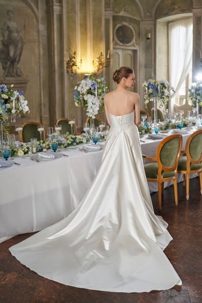 Vestido de novia de corte entallado, con cola de tafetán drapeada y cuello sin tirantes