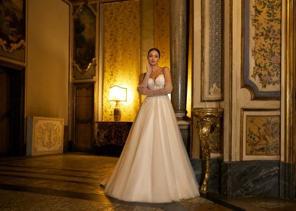 A-cut wedding dress model with sweetheart neckline, crystal embroidered lace, thin spaghetti straps, semi-transparent appearance