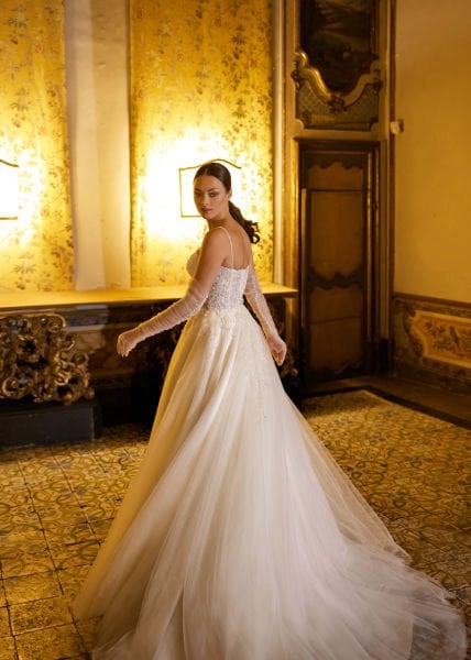 A-cut wedding dress model with sweetheart neckline, crystal embroidered lace, thin spaghetti straps, semi-transparent appearance