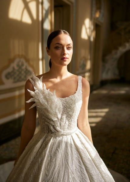 Semitransparente, escote cuadrado, tirantes gruesos, bordados de pedrería y pedrería de cristal, cola larga, Un modelo de vestido de novia hinchado.