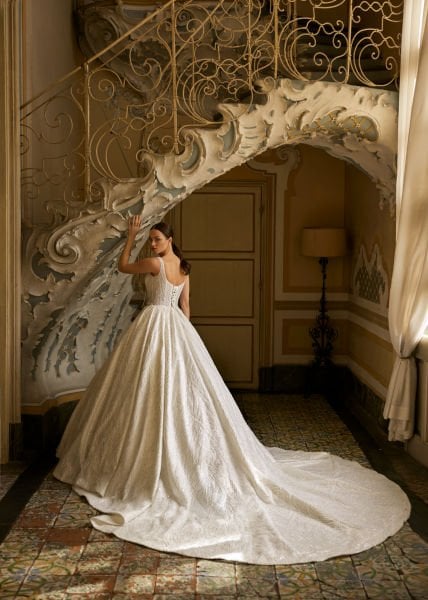 Semitransparente, escote cuadrado, tirantes gruesos, bordados de pedrería y pedrería de cristal, cola larga, Un modelo de vestido de novia hinchado.