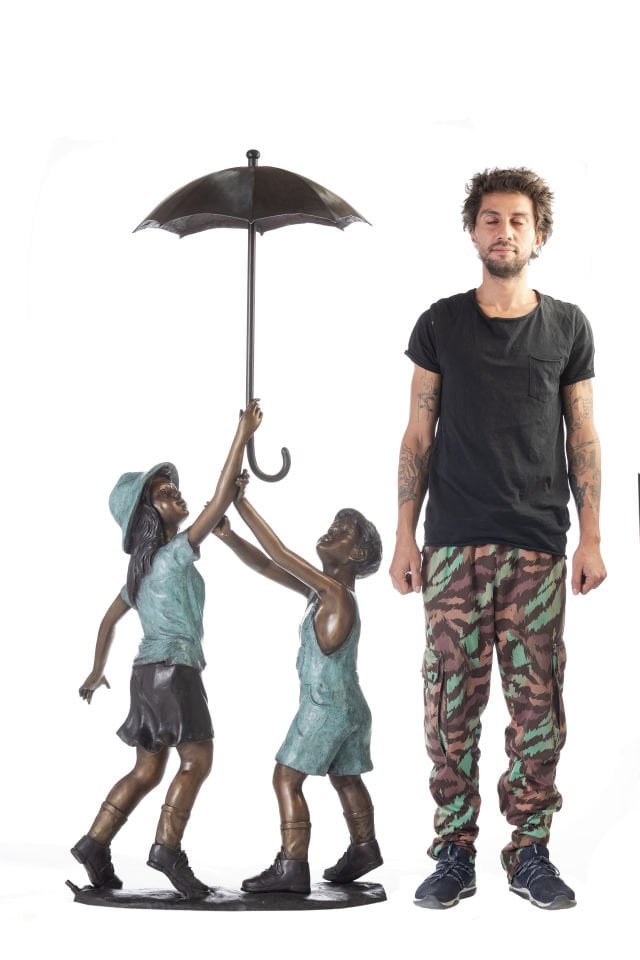 CHILDREN UNDER AN UMBRELLA FOUNTAIN