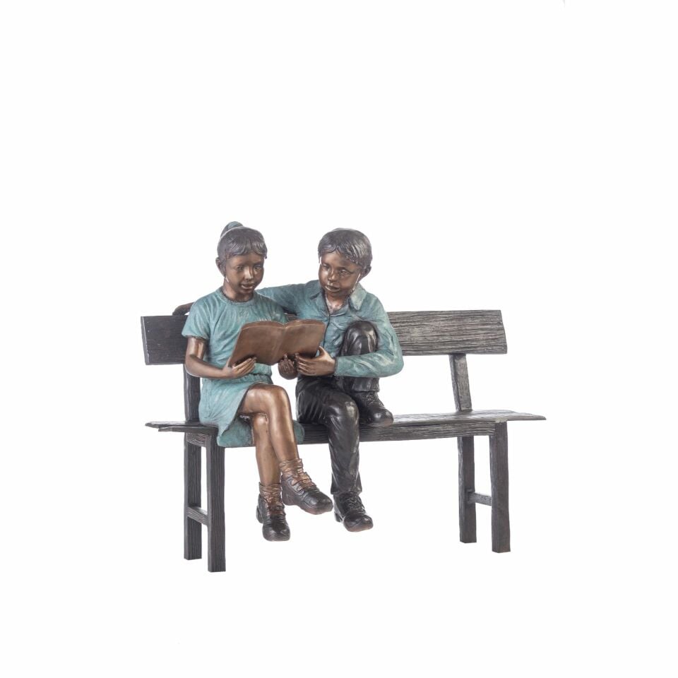 BOY AND GIRL READING A BOOK ON A BENCH